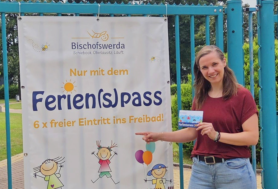 Madlen Raupach zeigt am Freibad Bischofswerda den Ferienpass und dessen sechs freie Eintritte