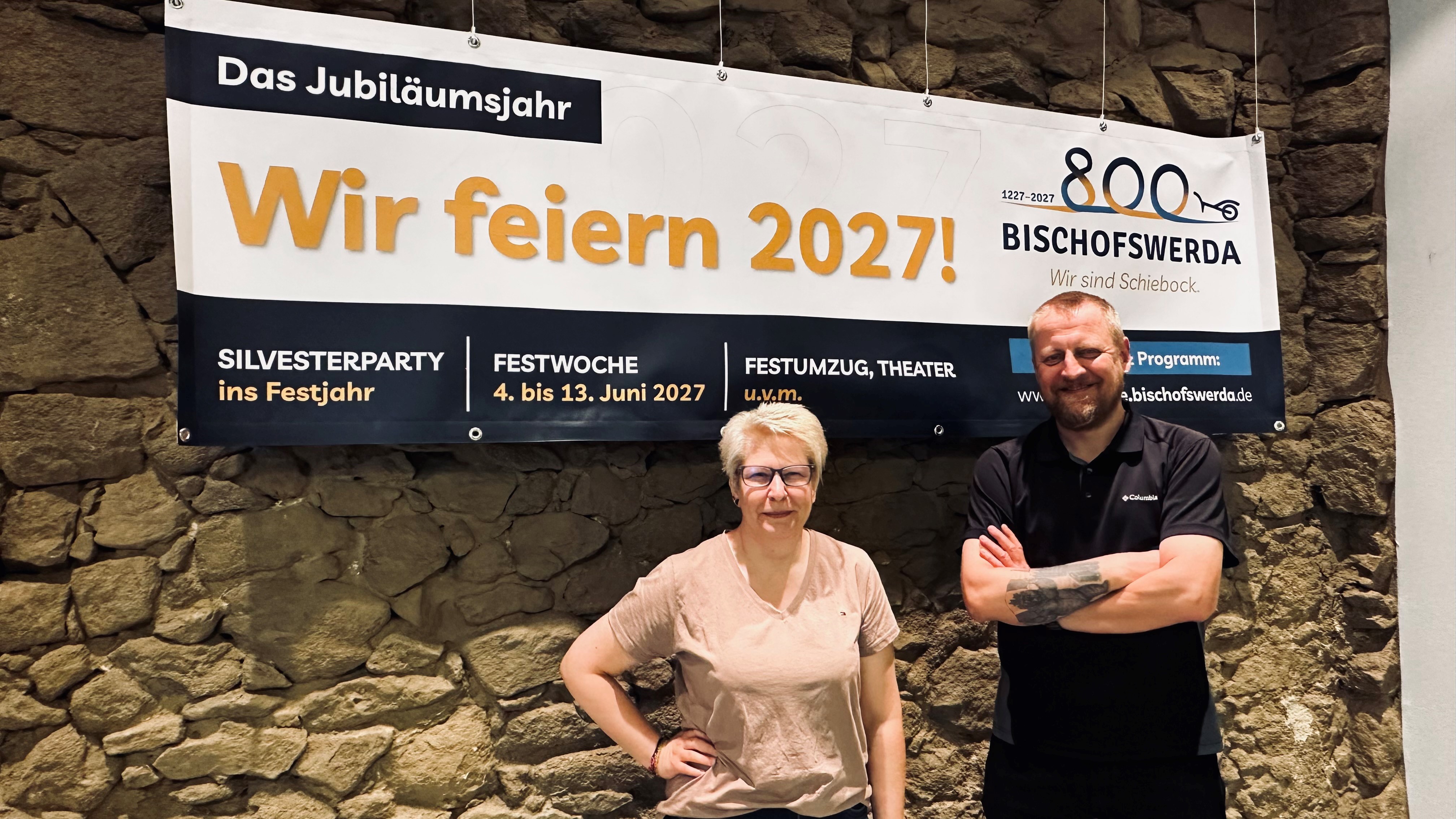 Jana Kalauch und Sascha Hache vor einem Banner zum 800-jährigen Jubiläum von Bischofswerda