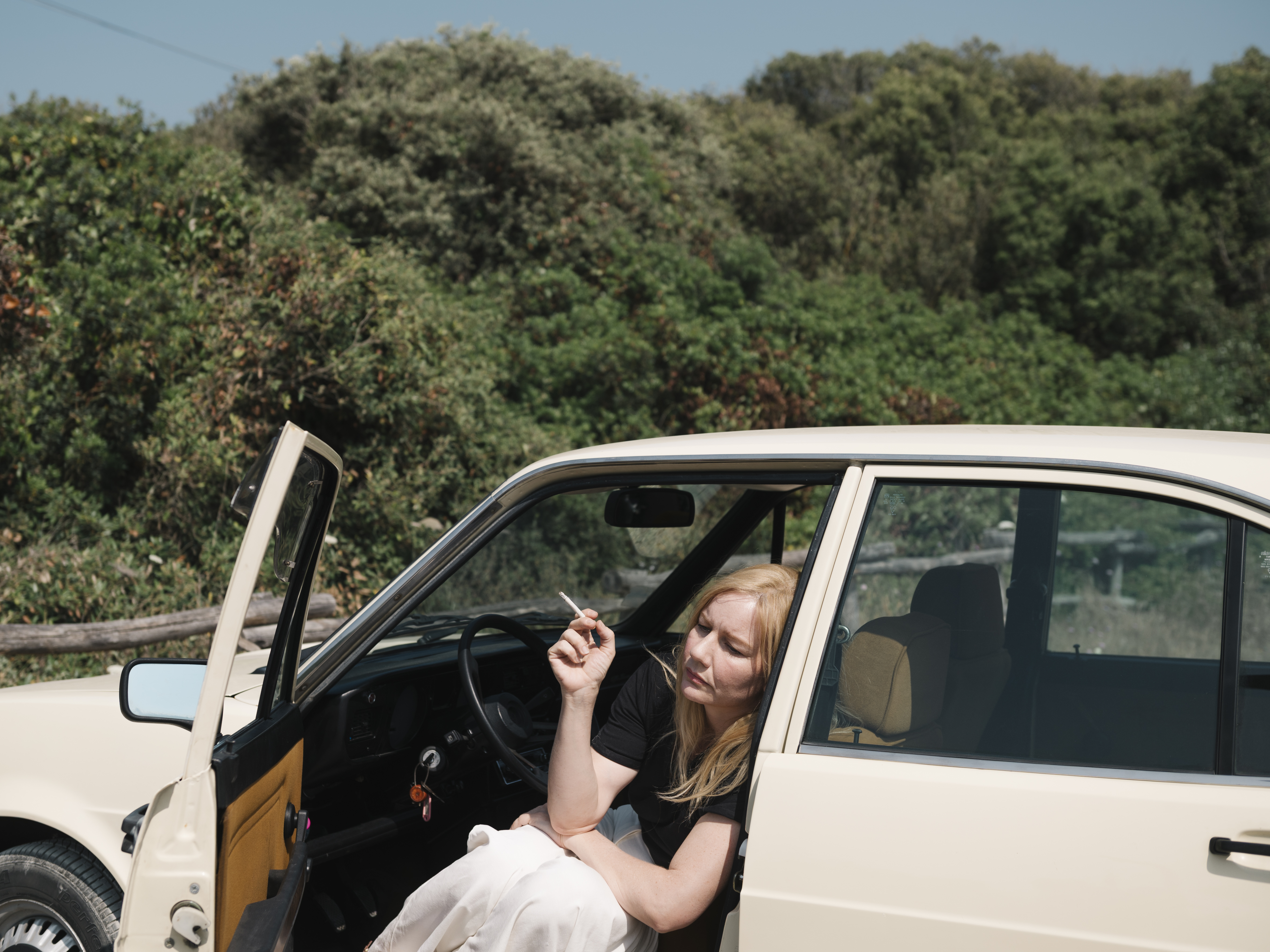 Nachdenklich sitzt Ingeborg Bachmann (Sandra Hüller) in ihrem Auto auf einem Parkplatz am Meer